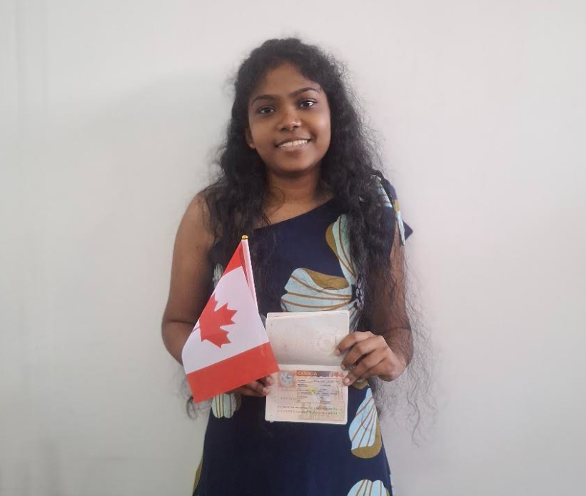 Siluni holding her Canadian study permit and a Canadian flag